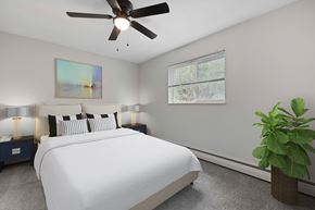 Lakewood apartment for rent - A bedroom with a large bed, a ceiling fan, and a potted plant.