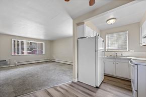 Denver apartment for rent - A kitchen with white appliances and wooden floors.