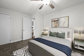 Arvada apartment for rent - A bedroom with a bed, nightstands, and a ceiling fan.