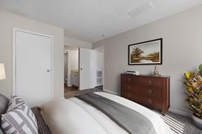 Aurora apartment for rent - A bedroom with a bed, dresser, and a painting on the wall.