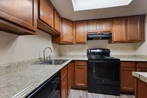 Aurora apartment for rent - A kitchen with brown cabinets and a black oven.
