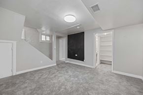 Denver apartment for rent - A spacious room with a staircase on the left and a blackboard on the right.