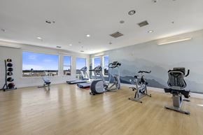 Denver apartment for rent - A gym with a variety of equipment including a treadmill, exercise bike, and weight bench.