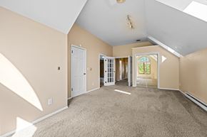 Denver apartment for rent - A spacious room with beige walls and carpeted floor.
