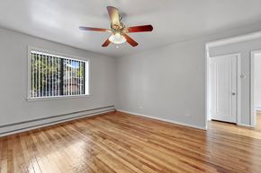 Denver apartment for rent - A room with a ceiling fan and a window with a view of trees.