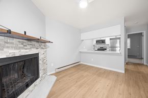 Boulder apartment for rent - A modern living room with a stone fireplace and wooden flooring.