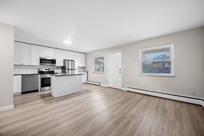 Boulder apartment for rent - A spacious kitchen with light wood flooring and white cabinetry.