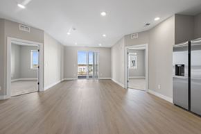 Arvada apartment for rent - A spacious, empty room with wooden floors and white walls.