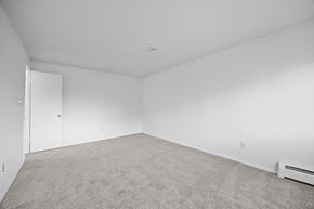 Longmont apartment for rent - A sparsely furnished room with a carpeted floor and a white door.