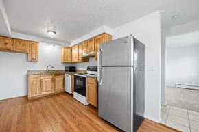 Longmont apartment for rent - A kitchen with wooden cabinets and a stainless steel refrigerator.