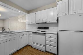 Boulder apartment for rent - A white kitchen with a sink, stove, and refrigerator.
