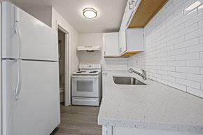 Westminster apartment for rent - A white kitchen with a refrigerator, oven, and sink.