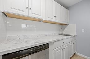 Edgewater apartment for rent - A kitchen with white cabinets and a marble countertop.