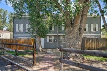 Lafayette triplex for rent - A grey house with a tree in front of it.