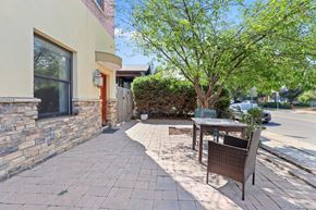 Denver apartment for rent - a patio with a table and chairs in front of a building