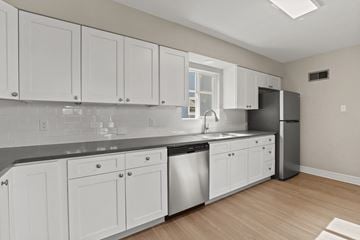 Denver apartment for rent - a renovated kitchen with white cabinets and stainless steel appliances