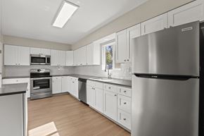 Denver apartment for rent - a kitchen with white cabinets and stainless steel appliances