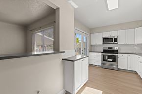 Denver apartment for rent - an empty kitchen with white cabinets and stainless steel appliances