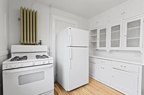 Denver apartment for rent - a kitchen with white appliances and white cabinets and a white refrigerator