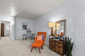 Greeley apartment for rent - a living room with a chair and a dresser and a mirror