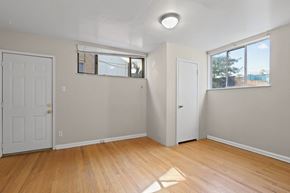 Denver apartment for rent - an empty living room with wooden floors and a white door and window