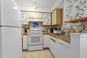 Boulder triplex for rent - A kitchen with white appliances and wooden cabinets.