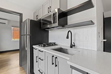 Denver apartment for rent - A kitchen with a black refrigerator and white countertops.