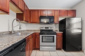 Denver apartment for rent - A kitchen with black appliances and wooden cabinets.