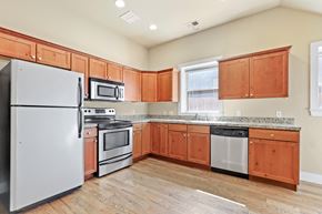 Denver apartment for rent - a kitchen with wood cabinets and stainless steel appliances