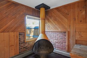 Lakewood apartment for rent - A large pot sits on a brick fireplace in a room with wooden walls.