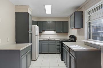 Lakewood apartment for rent - A kitchen with a black refrigerator and cabinets.