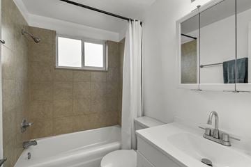 Englewood apartment for rent - A bathroom with a white tub and sink.