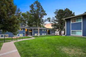 Littleton apartment for rent - A blue building with a green lawn in front.