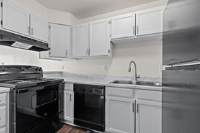Longmont apartment for rent - A kitchen with black appliances and white cabinets.