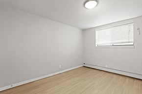 Denver apartment for rent - a bedroom with white walls and wood flooring and a window