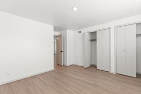 Lakewood apartment for rent - a bedroom with white walls and wood flooring and white closets