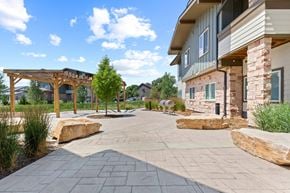 Fort Collins apartment for rent - the preserve at ballantyne commons community walkway with trees and rocks