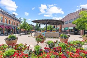 Fort Collins apartment for rent - A sunny day in a town square with a gazebo and flower beds.