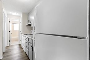 Denver apartment for rent - an empty kitchen with white cabinets and a white refrigerator
