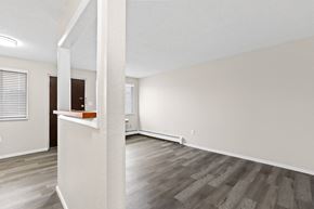 Denver apartment for rent - an empty living room with white walls and wood flooring