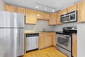 Denver apartment for rent - a kitchen with stainless steel appliances and wooden cabinets