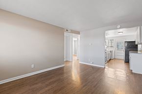 Denver apartment for rent - A spacious room with wooden flooring and a white ceiling.