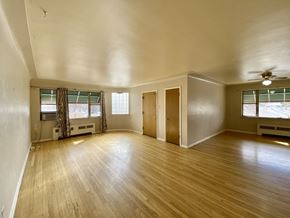 Denver apartment for rent - A room with wooden floors and a ceiling fan.