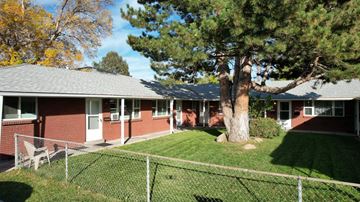 Wheat Ridge apartment for rent - A house with a red brick exterior and a tree in front.