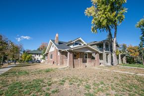 Denver apartment for rent - the front of a brick house with a yard and trees