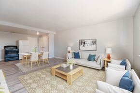 Denver apartment for rent - A living room with a white couch, a coffee table, and a painting on the wall.