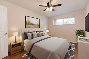 Denver apartment for rent - A bedroom with a large bed, a ceiling fan, and a painting on the wall.