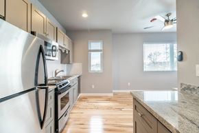 Lakewood apartment for rent - A modern kitchen with a stainless steel refrigerator and wooden flooring.
