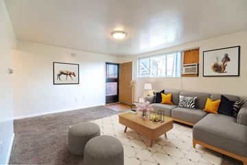 Lakewood apartment for rent - A living room with a grey couch, a coffee table, and a painting of a moose on the wall.