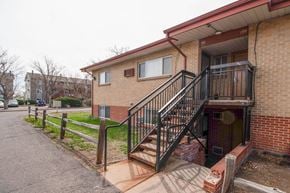 Lakewood apartment for rent - A brick building with a black railing staircase.